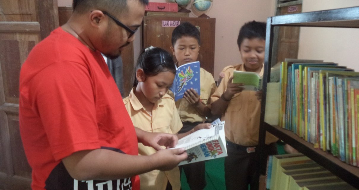 BUKU. Siswa dengan didampingi guru sedang memilih buku. (foto: ist)