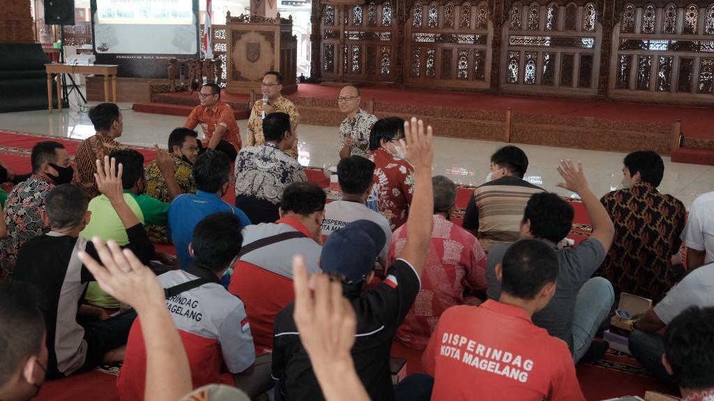 BERTANYA. Petugas kebersihan pasar tradisional mengangkat tangan untuk menyampaikan pertanyaan ke Wali Kota Magelang dr. Muchamad Nur Aziz dalam Ngopi Bareng. (foto: istimewa)