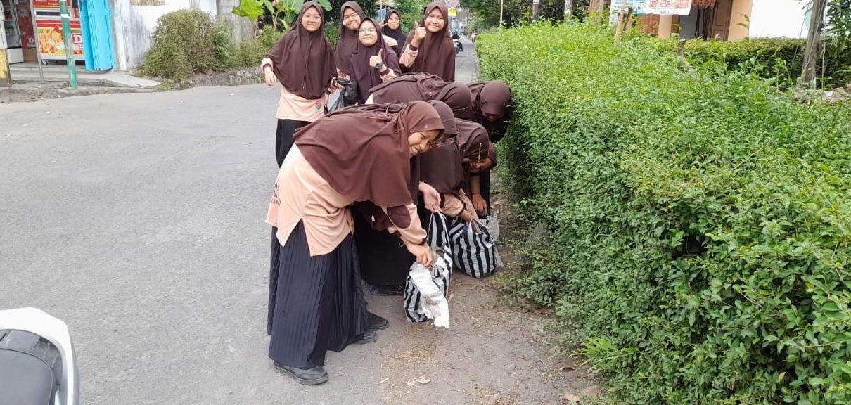 PUNGUT SAMPAH. SMP IT Ihsanul Fikri Mungkid melakukan kegiatan bakti masyarakat dengan memungut sampah di desa. (foto: ist)