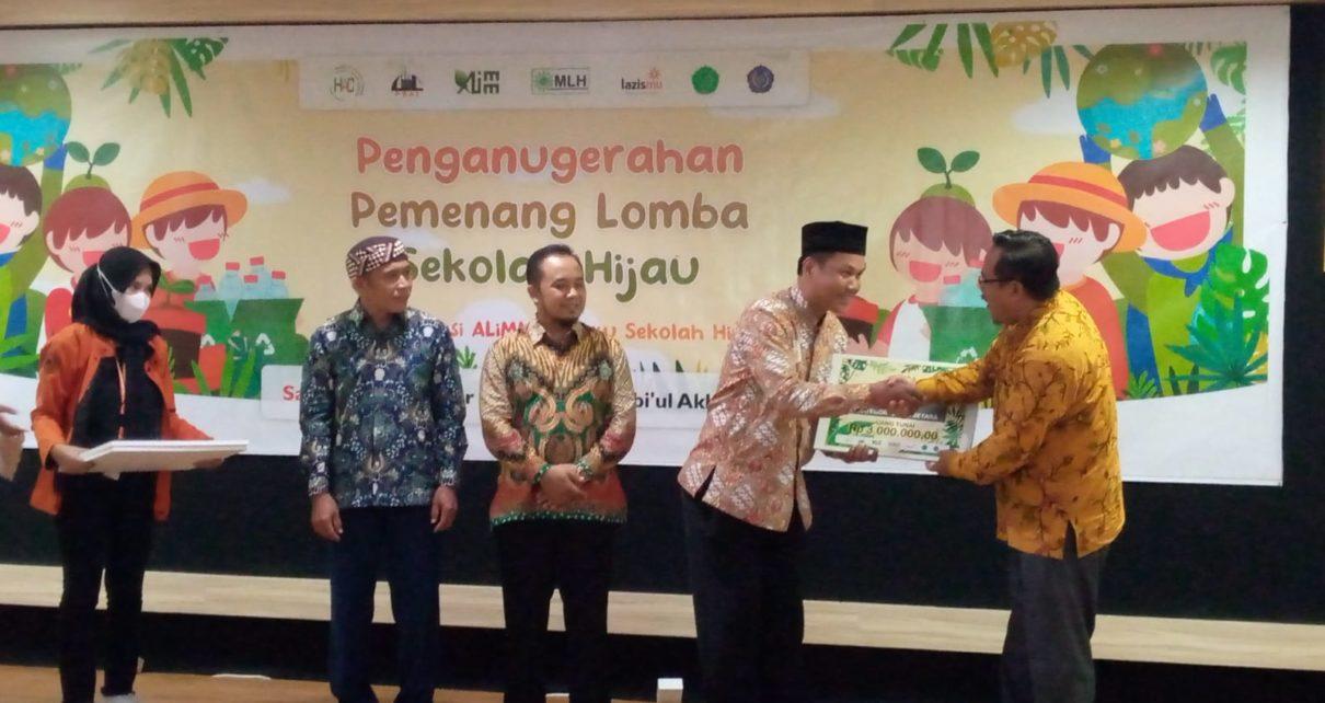 PENGHARGAAN. Ketua Majelis Lingkungan Hidup Pimpinan Pusat Muhammadiyah Prof. Dr. Ir. Muhyiddin Mawardi (kanan) menyerahkan penghargaan kepada Kepala SD Mutual 2 Kota Magelang, Mustaqim. (foto: istimewa)