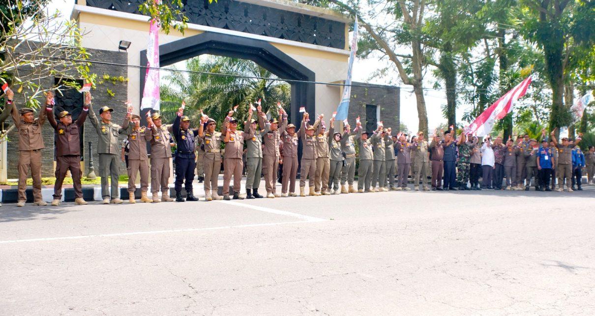 GANDENG TANGAN. Personel dengan bergandengan tangan membawa bendera di Jalan Sarwo Edi Wibowo, Rabu (15/3/2023). (foto: prokompimkotamgl)