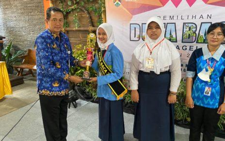 MENYERAHKAN. Kepala Dinas Perpustakaan dan Arsip Kota Magelang, Nurwiyono menyerahkan piala kepada pemenang. (foto: fida/siedoo)