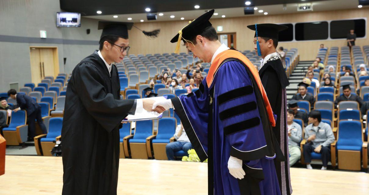 WISUDAWAN. Presiden Mokpo National University (MNU) Ha-Cheol Song (jubah biru) saat menyerahkan ijazah pada wisudawan program Joint Degree Teknik Perkapalan ITS dalam upacara wisuda. (foto: its)